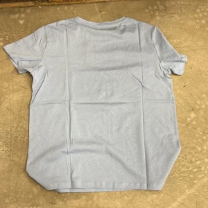 Ljusblå t-shirt - Säljer en enkel och stilren ljusblå t-shirt. Perfekt för en avslappnad look. T-shirten har korta ärmar och en rund halsringning.