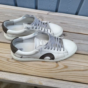 Oliver Cabell sneakers - Snygga vita sneakers från Oliver Cabell  med grå snörning. Skorna har en låg profil och en bekväm passform.