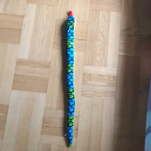 En gossedjurs orm med  Blå-grönt mönster  - Säljer en gossedjurs orm med blå-grönt mönster den har rosa ögon och en röd tunga. Den är köpt ifrån fun ideas. 