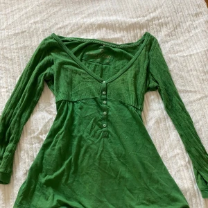 Söt topp - En grön söt topp. Som ni kan se på bilden så förekommer två små hål på armen, annars fint skick.