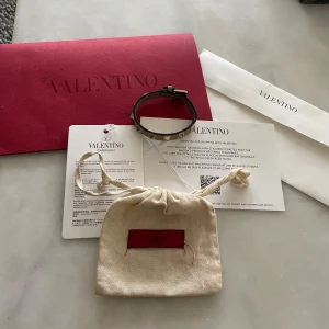 Valentino armband  - Säljer det här valentino armbandet, fint skick. Lite slitet längst ut, (syns på sista bilden) allt tillbehör ingår. Dustbag, kuvert, kort etc. Tveka inte på att kontakta vid frågor!
