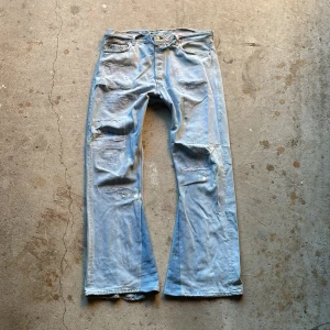 Distressed baggy flare jeans - Baggy flared jeans med distressing. Vintage skick med hål och fläckar. Baggy passform