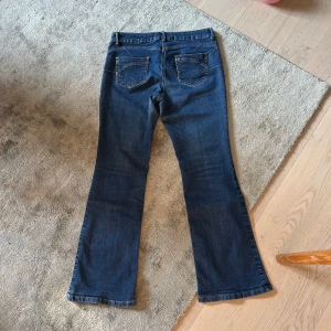 Mörkblå bootcut jeans - Mörkblå jeans med bootcut flare jeans med cool detalj vid fickorna, skulle säg att de passar 36/S