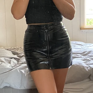 Svart skinnkjol (fake) med dragkedja - Använd men i gott skick, sitter tajt med ändå stretchig. Väldigt skön!