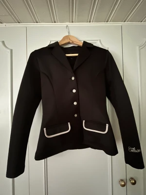 CRW tävlingskavaj  - (Laddar upp annonsen igen då kontot buggat). Superfin kavaj som jag vuxit ur och därför säljer jag den:). Den är liten i storleken så är mer som en 36. Inga skavanker, bara liten slitning i armhålan som ej syns. (Inget hål), tvättas innan leverans! 