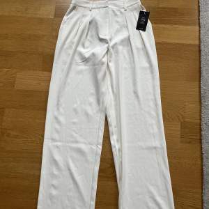 Vita, loose fit kostymbyxor från NA-KD. Högmidjade Strl 36. Aldrig använda.
