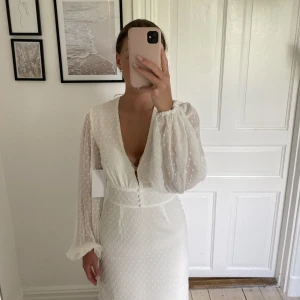 Vit klänning - Fin och lång vit klänning med prickar på. Klänningen är från NA-KD och säljes pga att jag valde en annan storlek. Aldrig använd och har prislappar kvar. Ursprungs pris 799 kr. 