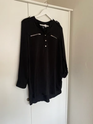 Klänning - Skjortklänning i ett svalt lite blankt material från H&M divided. Går att ha med ett tunnare bälte för mer kroppsnära modell. I bra skick och nytvättad. 