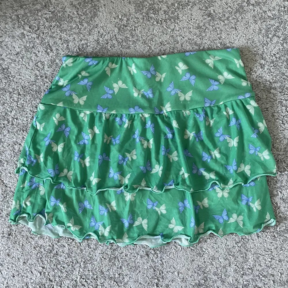Lågmidjad grön kjol med fjärilar från H&M✨Säljer pga används inte, bra skick🌸. Kjolar.