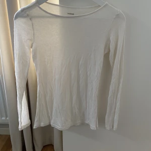 Tunn vit långärmad tröja.  - Mycket tunn vit långärmad tröja. Sitter tight runt överkroppen. Tröjan är hyfsad genomskinlig. 