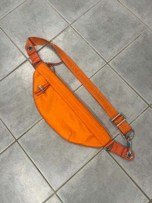 Lacoste väska  - Orange väska från Lacoste i nyskick, ingenting att anmärka på