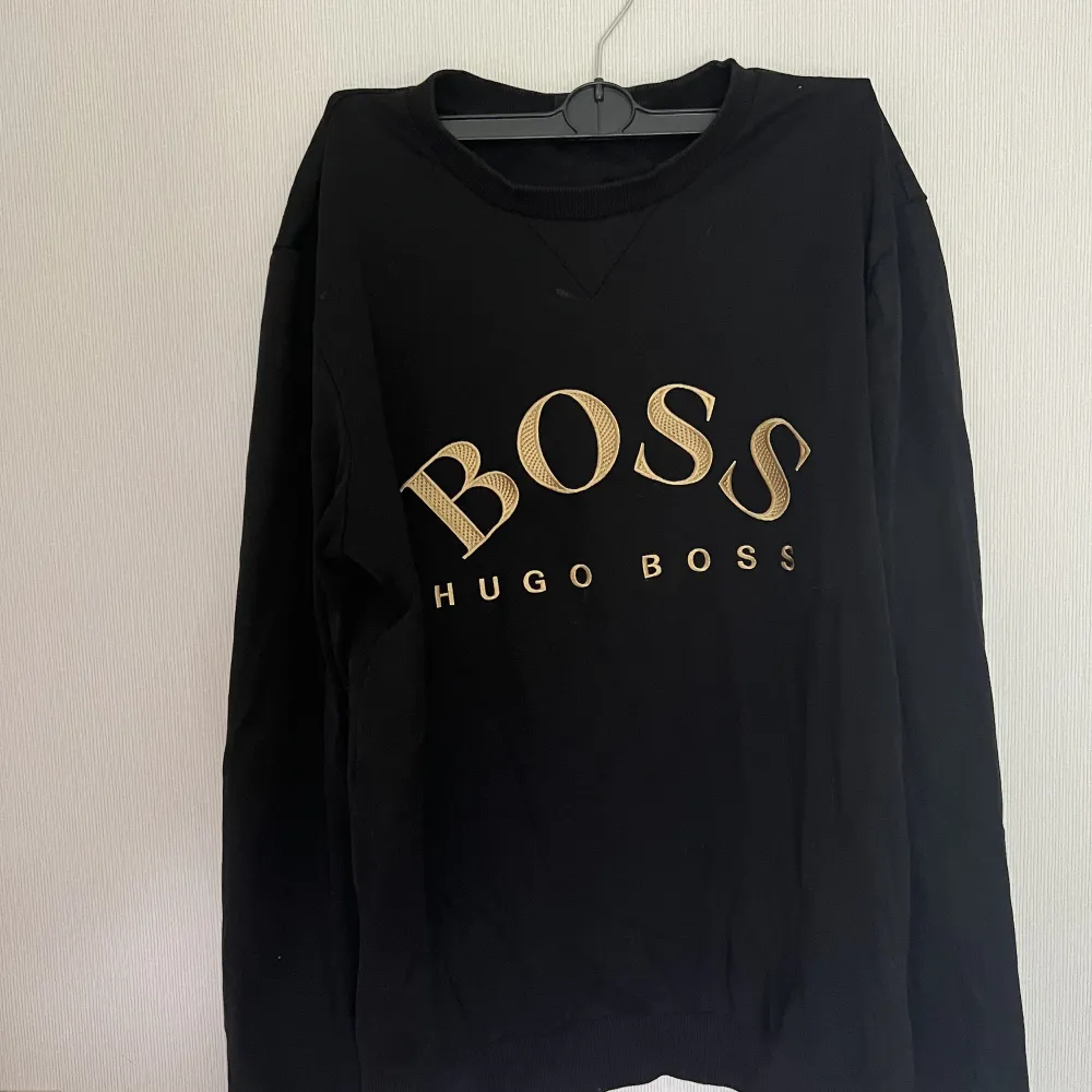 En svart Hugo boss t-shirt med loggan i guld på bröstet. Storlek L i herr. Använd ett par gånger men i gott skick. . Tröjor & Koftor.