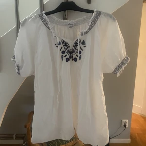 Jättesöt blus  - Superfin vit blus med blå detaljer. Mycket bra skick. Skulle säga att den är stl M/40. 