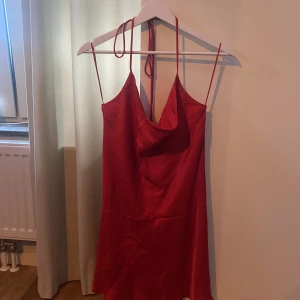 Gullig röd klänning i silke  - Röd klänning i silke från Zara. Knyte runt halsen som man kan justera själv. Aldrig använd. 