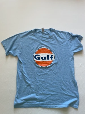 Blå Tshirt - Säljer denna superfina tshirten med trycket ”Gulf” i storleken M. Finns att hämta upp i Stockholm o kan också fraktas.