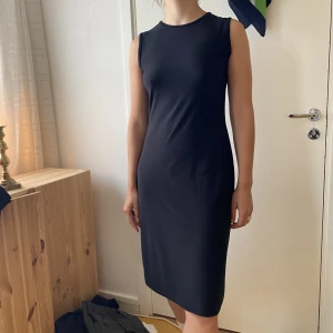 Svart klänning  - Svart stretchig clean klänning!! Storlek L men sitter som på bilden på en 38/40. Hittar inga tråddragningar, sååå fin!