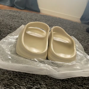 Beigea tofflor - Adidas yeezy slides färg: Bone (beige), helt oanvända.