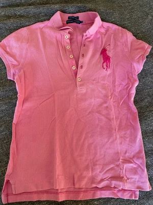 Pikétröja  - Supersöt och cool pike tröja från Ralph lauren. Fin kroppsstrumpa och sitter tightare vid midjan. Köpt på secondhand och har aldrig själv använt. Passar perfekt nu till sommaren och våren💓skriv privat för fler bilder. 