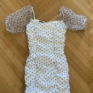 Vit klänning - Så fin kortare klänning, vit med svarta prickar. Passar i längden för mig som är 165cm. Storlek 36🥰