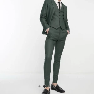 Gröna kostymbyxor - Helt nya, oanvända ”skogsgröna, superskinny kostymbyxor i linnemix” från ASOS. Säljes eftersom jag missade returen och säljer även kavajen i annan annons. Väldigt fin färg i verkligheten, tyget tjockt och fint. Har kvar påsen de skickades i. Nypris 499