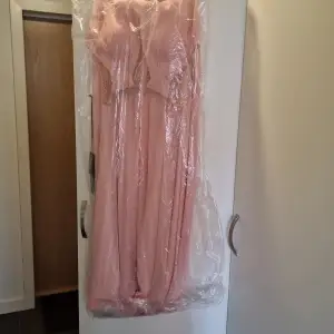 Klänning oöppnad fortfarande ettikett och plasten kvar, persiko färgad, möjligtvis balklänning eller cocktail klänning 