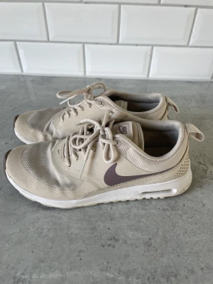 Nike sneakers - Nike sneakers i använt skick, går att tvätta! Beigea med lila märke 🌸 Storlek 37,5 men passar även 36