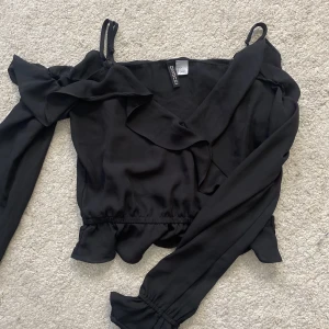 Svart blus  - Svart fin volangblus från hm som är öppen vid axlarna!🖤