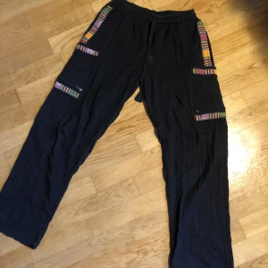 Tygbyxor - Hippie-aktiga tygbyxor med många fickor på sidorna. I linnetyg. Fint skick, skriv för fler bilder