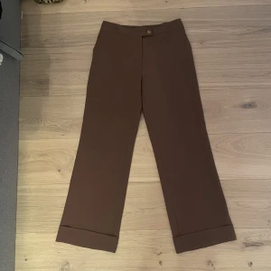 Lågmidjade kostymbyxor  - Jätte fina baggy bruna kostymbyxor sitter lågmidjade 38cm rakt över75cm inneboende hela längden 100cm