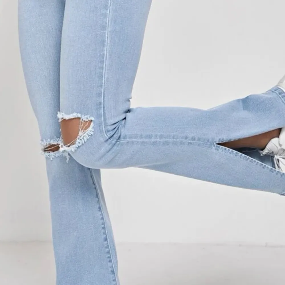 Ett par blåa utsvängda jeans med små hål. Helt nytt skick,super fina och sitter perfekt . Jeans & Byxor.