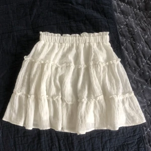 Vit vilangljol - Jättefin vit volangkjol😻Har en superligan fläck på framsidan (se bild), men inget som märks. Vet tyvärr ej vart den kommer ifrån❤️