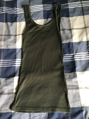 H&M DIVIDED Linne - H&M DIVIDED grön lång linne, linnet är väldigt strechig som gör så att det sitter bättre på kroppen, andvänt några gånger men är i bra skick, är i stoelk XS men skulle kunna passa S