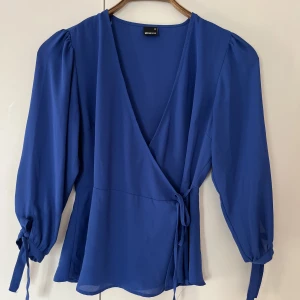 Blus frpn Gina Tricot - Blå blus från Gina. Väldigt fint material blir aldrig skrynkligt. Inte nopprig och i väldigt fint skick.