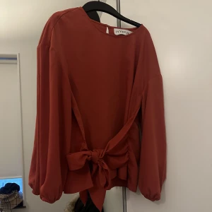 Blus med knytband  - Blus med knutband i midjan från ivyrevel, röd/orange