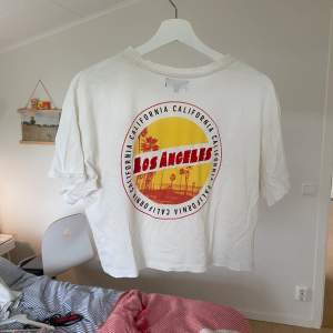 Vit t-shirt med gött tryck på ryggen. Strl. S/M