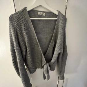 En grå stickad tröja som är knuten framtill, från chiquelle, superfin💞🥳Den är onesize men passar jättebra på mig som är Medium🥰 Har fler bilder vid förfrågan💞