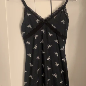 Klänning  - En fin klänning från H&m med vita fjärilar på, aldrig använd för tycker inte den passar mig, stl xs, juster bara band