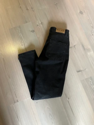NA-KD ”mom jeans”  - Svarta mom jeans från NA-KD i storlek 32. Högmidjade. Aldrig använda, endast provade, så i nyskick. Säljes då de inte passar mig. Nypris 399kr, mitt pris 230kr plus frakt.  Har mycket fler plagg ute tillsalu! 
