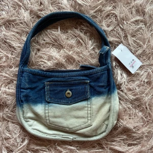 Liten jeansväska  - Gullig liten jeansväska, köpt secondhand men aldrig använd.   22 cm bred och 15 cm hög 