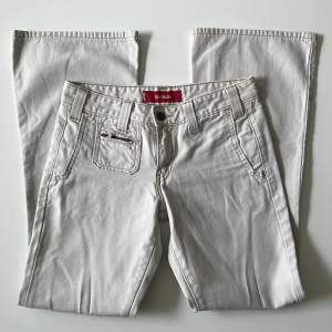 Vita / beiga lågmidjade bootcut jeans från Levi’s. Midjemått: 72 cm. Innerbenslängd: 75 cm. Hon på bilderna är 167 cm lång 💕