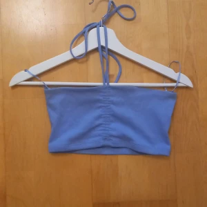 Blå topp - Blå kort topp med snören, mjukt och mellan tjokt matrial. Orginal priset var 149kr. Köpte innan somaren och använd 2 gånger. Säljer pågrund av att den är för kort för mig. Storleken är S och passar bra på mig som är 164cm. Tvättas innan den skickas.💙