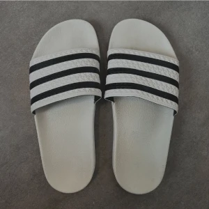 Tofflor - Adidas tofflor som aldrig kommit till användning pga för liten storlek. Dom är i storlek 38 men skulle rekommendera att dom mer passar 35-37. 