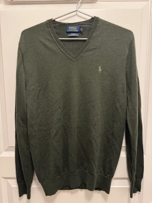 Ralph Lauren V-Neck - Fin Ralph lauren V-neck som inte enda är använd 5 ggr. Mörkgrön färg och storlek slim fit medium, men passar som en regular small. 