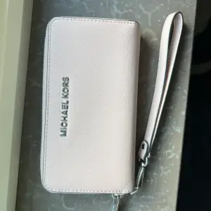 Ljusrosa/beige plånbok från Michael Kors i skin. I fint skick, nästan aldrig använd!
