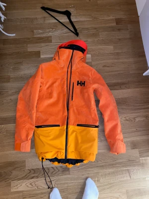Helly Hansen jacka - Helt ny unik helly hansen jacka. Använd 1 gång i 10 min så knabbt använd. Den är Manchester på utsidan och dun på insidan. Jackan har 2 lager och är sjukt varm. Perfekt skidjacka och otroligt stilren. 5 fickor och har ett luftintagshål med dragkedja.