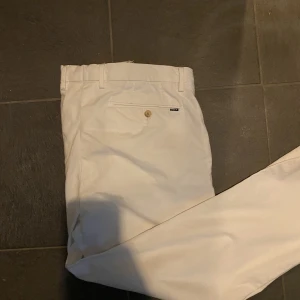 Ralph Lauren Vita Chinos - Ett par vita chinos från Ralph Lauren. Byxorna är bara använda en gång och dom är i ett fantastiskt skick. Hör av er vid frågor
