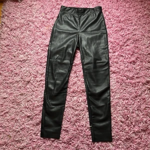 Skinbyxor i fake skin  - Det är tighta skinbyxor med resor i midjan 