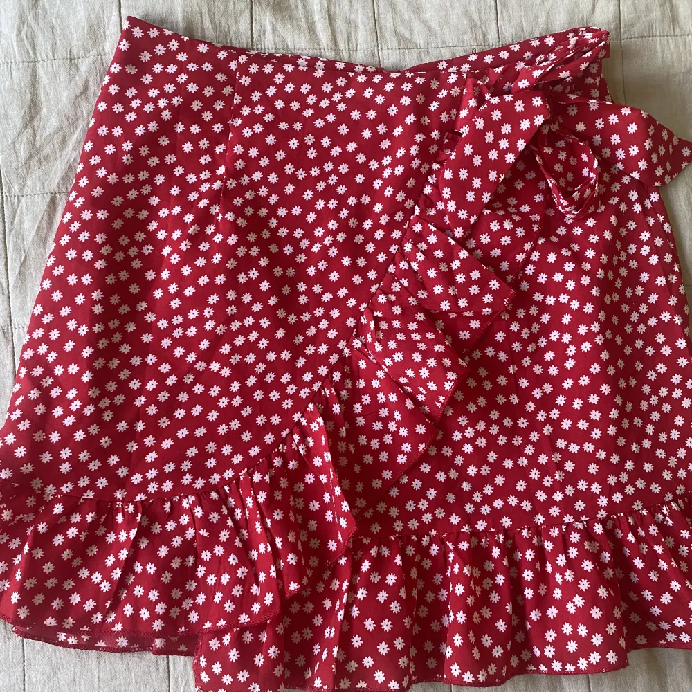 Röd kjol med vita blommor och volang, storlek S från shein❣️. Kjolar.
