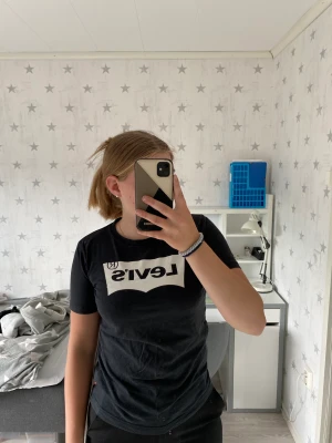 Levis t-shirt  - Säljer en svart Levis t-shirt med vit logga. Sparsamt använd så i väldigt fint skick. Storlek 164 barn men passar xs.