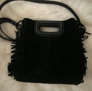 Maje väska - Säljer nu min stora svarta Maje väska i mocka pga den inte kommer till användning❤️den har inga defekter och jag har kvar dustbagen❤️den är köpt på nk i sthlm❤️kontakte för frågor och annat❤️